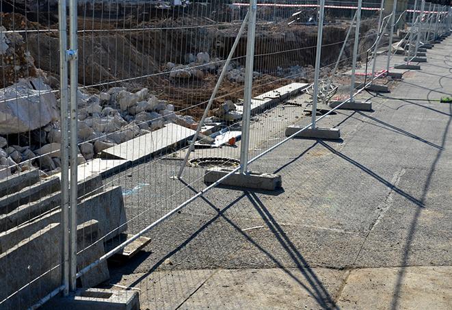 a row of temporary fence panels providing a barrier for safety and security